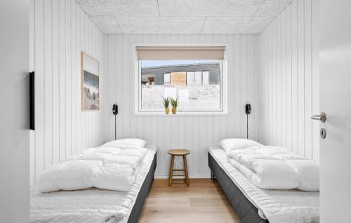 a white room with two beds and a table at Stunning Home In Løgstrup With Kitchen in Løgstrup