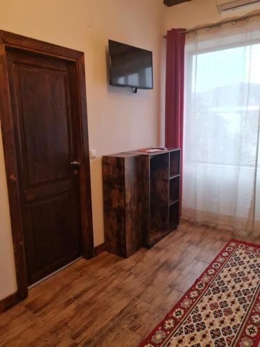 a room with a door and a television on the wall at Conacul Ancuței in Brad