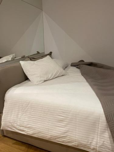 łóżko z białą pościelą i poduszkami w pokoju w obiekcie Wip Appartament Solec rezidencia w Warszawie