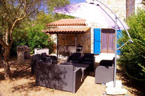 - un kiosque avec des chaises noires et un parasol dans l'établissement Meublés de Tourisme Casa Erbaggio, à Sartène