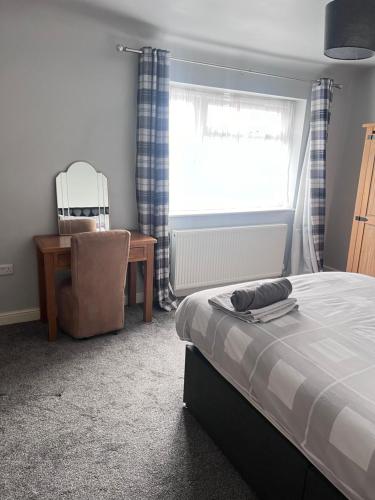 a bedroom with a bed and a chair and a window at House near city centre in Leicester