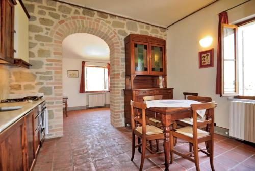 a kitchen with a table and a stone wall at I Casali Della Ghisleria in Ospedalicchio