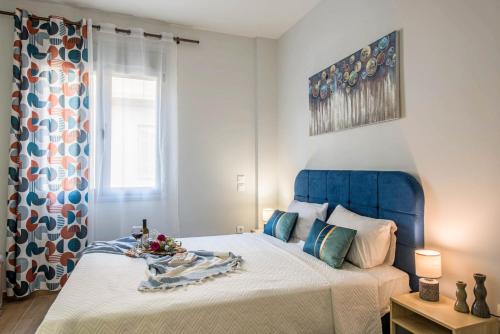a bed with a blue headboard in a bedroom at Elegant, Spacious and hitech apt at Koukaki in Athens