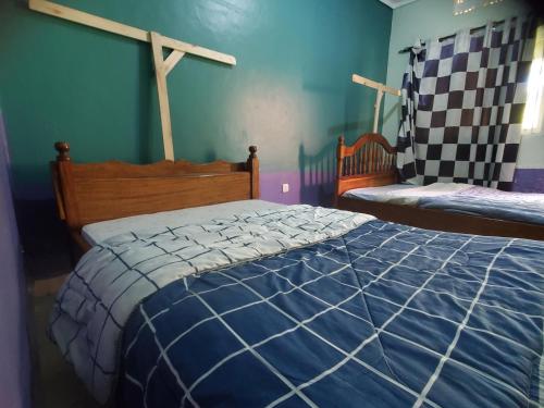 a bedroom with a bed with a blue and white comforter at Havannah Campsite and Homestay in Fort Portal