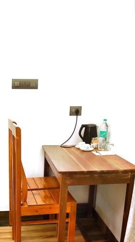 einen Holztisch mit einer Teekanne darauf in der Unterkunft Sandcastle in Kochi