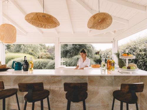 San Vero MilisにあるIs Cheas wine farm boutique hotelの家の台所カウンターに腰掛けている女性