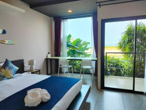 a bedroom with a bed and a large window at The Beach Resort & Residence - SHA Plus in Pathiu