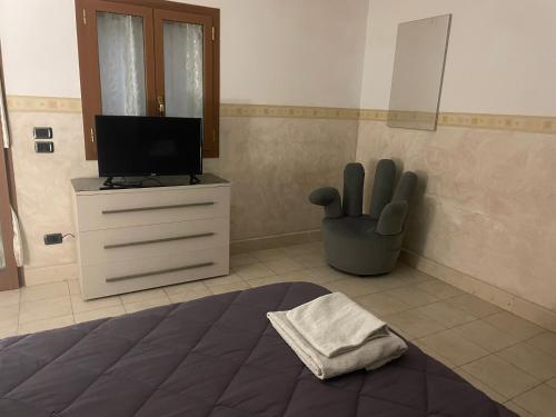 een slaapkamer met een bed en een tv op een dressoir bij La Dependance in Barletta