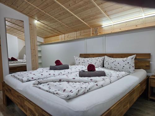 un grande letto con due cuscini rossi sopra di Gasthof Pension Kohlplatzl a Hopfgarten in Defereggen