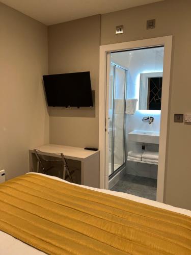 a bedroom with a bed and a bathroom with a sink at Hendon Studios in The Hyde