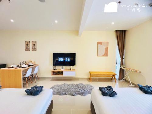 a living room with two beds and a television at The Shore Maison Life 小居屋 in Kota Kinabalu
