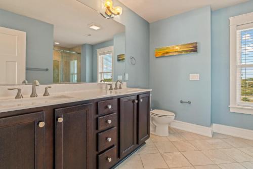 a bathroom with two sinks and a toilet at Surfside Retreat 7 Bedroom by KEES Vacations in Buxton
