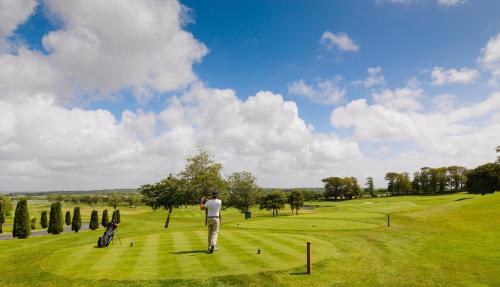 a man standing on a lush green golf course at Glenlo Abbey Hotel in Galway