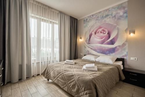 a bedroom with a large pink rose painting on the wall at Zaporizʹka Sich in Bukovel