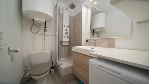 La salle de bains blanche est pourvue de toilettes et d'un lavabo. dans l'établissement Balcon des Neiges 124 - Appt moderne 4 pers, à Allos