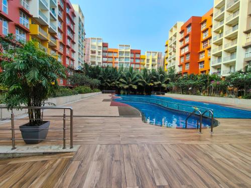 a swimming pool in an apartment complex with buildings at Glistening 2BHK Pool View, Resort Living, 10 mins from Dabolim Airport by Zennova Stays in Dabolim
