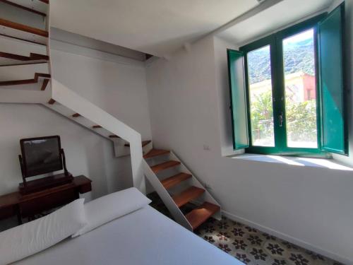 Habitación con cama y escalera con TV. en Iancura - B&B di design a Salina, en Santa Marina Salina