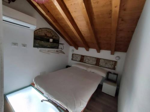 Cama en habitación con techo de madera en Iancura - B&B di design a Salina, en Santa Marina Salina