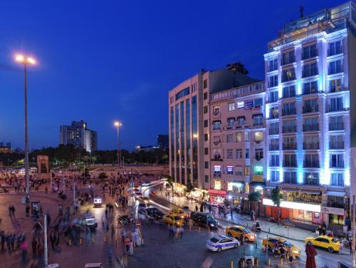 فندق سي في كي تقسيم إسطنبول في إسطنبول: شارع المدينة مزدحم ليلا بالسيارات والناس
