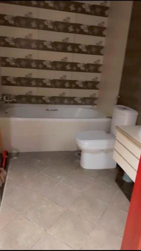 a bathroom with a white tub and a toilet at عجمان in Ajman 