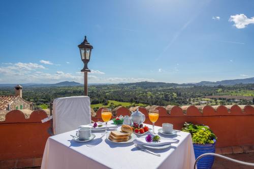 einen weißen Tisch mit Speisen und Getränken auf dem Balkon in der Unterkunft Finca Es Castell in Binibona