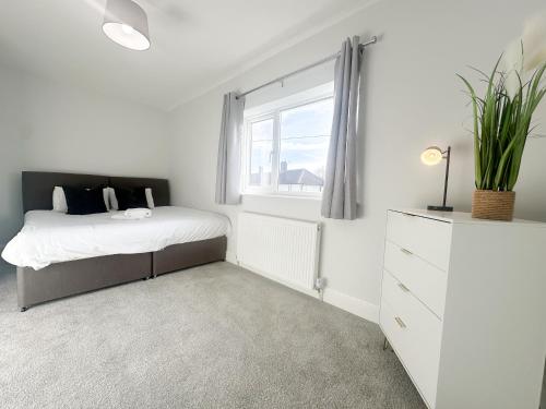 a white bedroom with a bed and a window at York House by Blue Skies Stays in Stockton-on-Tees