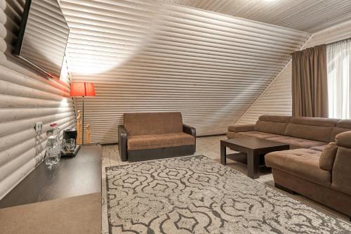 uma sala de estar com um sofá e uma cadeira em Zaporizʹka Sich em Bukovel