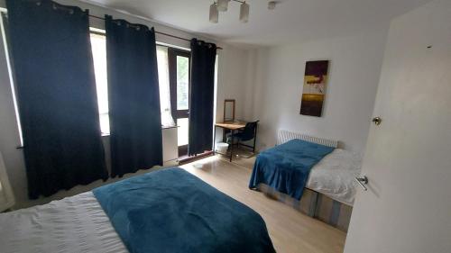 a bedroom with two beds and a window at Sandfield Private Rooms in King's Cross St Pancrass in London