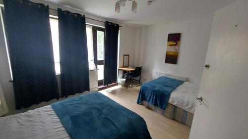 a bedroom with two beds and a window at Sandfield Private Rooms in King's Cross St Pancras in London