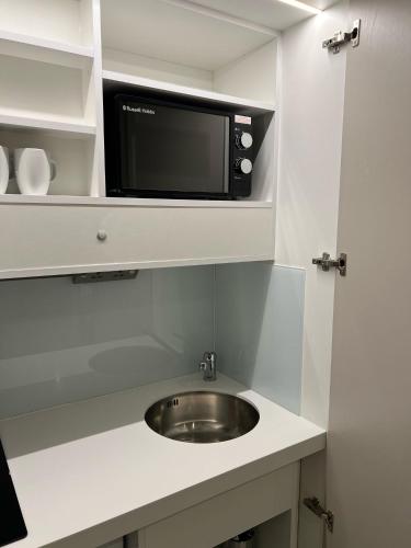 a kitchen with a sink and a microwave at Hendon Studios in The Hyde
