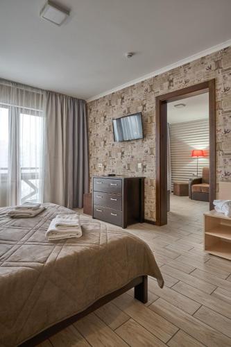 a bedroom with a bed and a television on a wall at Zaporizʹka Sich in Bukovel