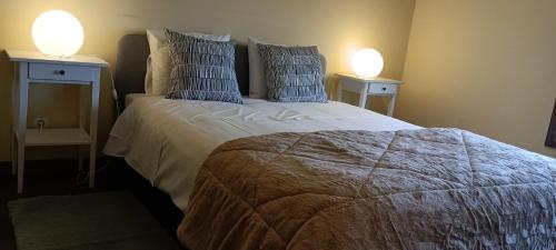 馬托西紐什的住宿－Matosinhos -Seas Apartment- Cabo das Marés，一间卧室配有一张带两盏灯的床。