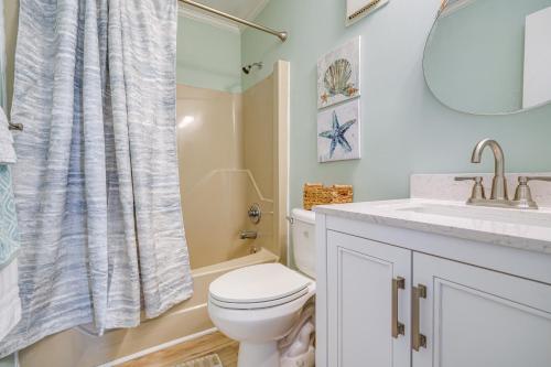a bathroom with a toilet and a sink and a mirror at Kill Devil Hills Condo with Beach Access On-Site! in Kill Devil Hills