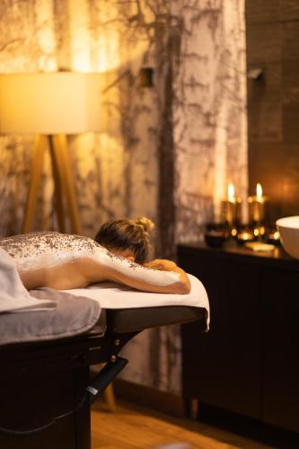 a woman is laying in a bath tub at Szczawnica Park Resort & Spa in Szczawnica