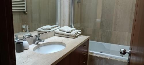 a bathroom with a sink and a mirror and a tub at Matosinhos -Seas Apartment- Cabo das Marés in Matosinhos