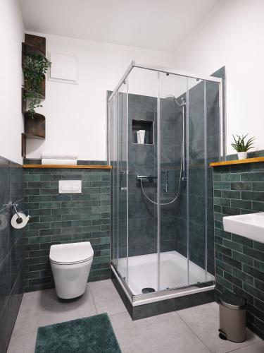 a bathroom with a shower and a toilet and a sink at Hannover - PHIL & MAX Hotels und Apartments Airport in Hannover