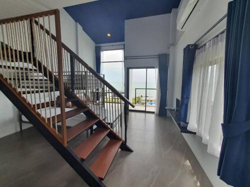 a staircase in a room with a blue ceiling at The Beach Resort & Residence - SHA Plus in Pathiu