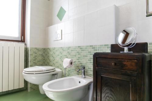 a bathroom with a toilet and a sink and a mirror at Relax house Baveno in Baveno
