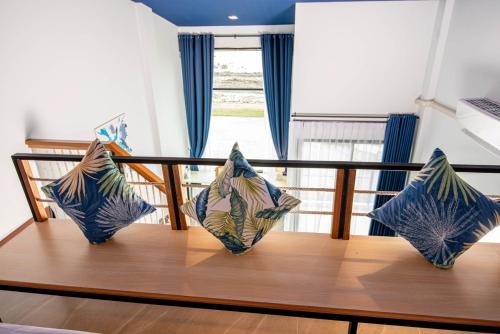 three pillows sitting on top of a wooden table at The Beach Resort & Residence - SHA Plus in Pathiu