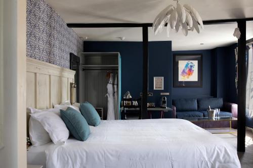 1 dormitorio con 1 cama blanca grande y paredes azules en The White Lion en Tenterden