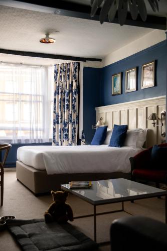 a bedroom with a large bed with blue walls at The White Lion in Tenterden
