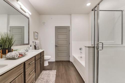 a bathroom with a shower and a toilet and a sink at ALL034 - Luxe 2BD 2BA Apt in Allen in Allen