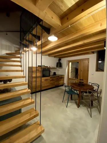 a staircase in a room with a table and a kitchen at Ca'Gialla in Bellinzona