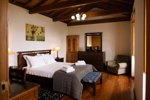 1 dormitorio con 1 cama y 1 silla en Villa Mistério en São Roque do Pico
