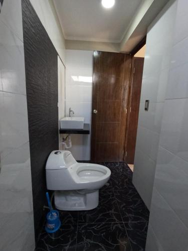 La salle de bains est pourvue de toilettes et d'un lavabo. dans l'établissement Millpu Hostal, à Ayacucho