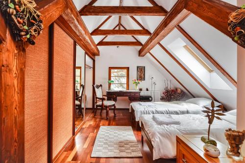 a attic bedroom with two beds and a desk at Willa nad Popradem in Piwniczna