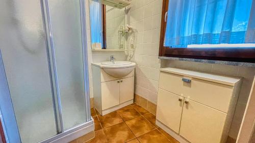 a small bathroom with a shower and a sink at Appartamento Smith Moscato - Affitti Brevi Italia in Bardonecchia