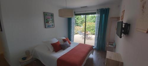 een slaapkamer met een bed met kussens en een raam bij Gîte de charme in Garéoult