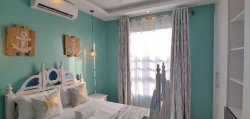 a bedroom with a white bed and a window at Homes By Sandra in Kilifi