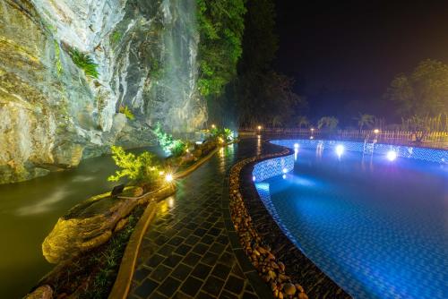 uma piscina à noite junto a uma cascata em Indochine Boutique Hotel Ninh Bình em Ninh Binh